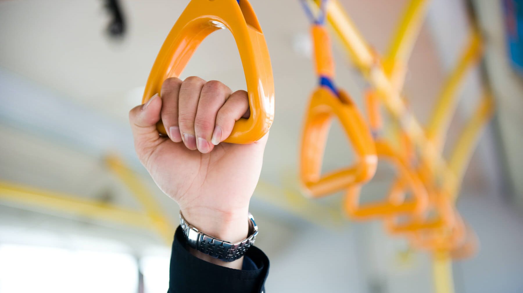 Fahrgast hält sich an Halteschlaufe in Bus fest