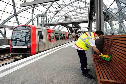 Mitarbeiter des Hochbahn-Hygieneteams reinigt Sitzfläche am Bahnsteg.