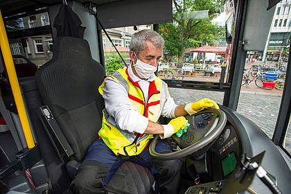 Mitarbeiter des Hochbahn-Hygieneteams reinigt das Bussteuer.